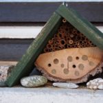 Ein kleines Insektenhotel mit grünem Dach.