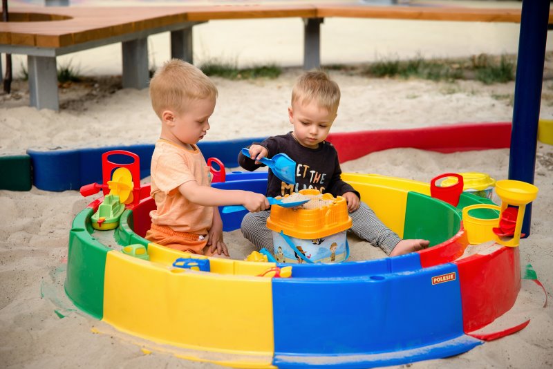 Kinder spielen mit Wasser und Sand