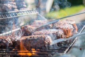 Brennender Grill mit mehreren Steaks