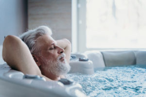 Ein Mann liegt im Whirlpool und genießt das Spät-Erlebnis.