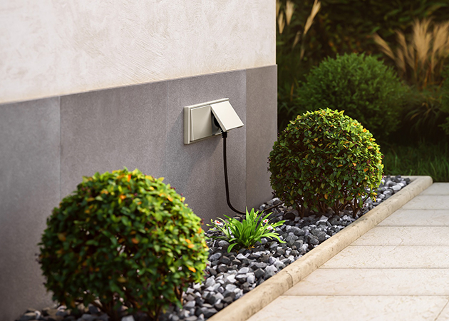 Eine in einer Hauswand integrierte Gartensteckdose